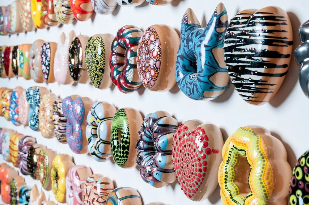 Donut think to much, Be Happy; Artist: Jae Yong Kim; ceramic, under glaze, glaze, luster glaze, Swarovski crystals; Installation size: 66 x 80.5 x 1.5 in. 201